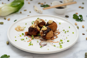 A plate of takoyaki over a marble table