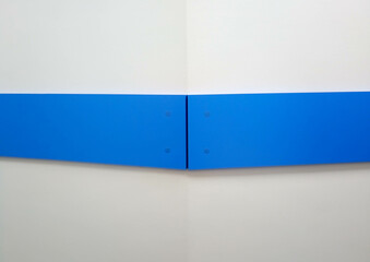 Background of the corner of a white wall with a blue stripe