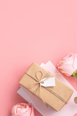 Mother's Day design concept background with pink rose flower and gift on pink background.