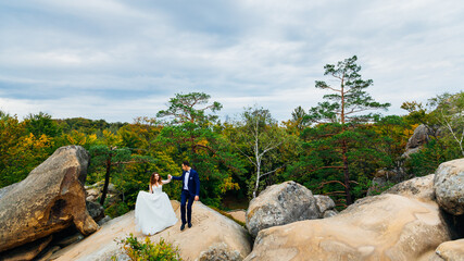 walking couple on rocks on beautiful nature