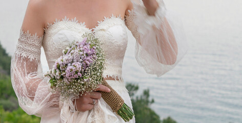 hand of bride holding flower bouquet outdoor