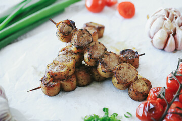 Shashlik or shish kebab prepared on barbecue grill over hot charcoal with grilled vegetables. Grilled pieces of pork meat on metal skewers.
