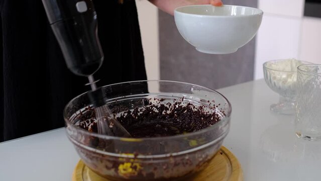 mixed yolk eggs, flour and sugar prepare for baking cake or bake. Process of making brownie. Stirring ingredients in a glass bowl.