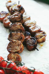 Shashlik or shish kebab prepared on barbecue grill over hot charcoal with grilled vegetables. Grilled pieces of pork meat on metal skewers.