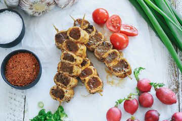 Shashlik or shish kebab prepared on barbecue grill over hot charcoal with grilled vegetables. Grilled pieces of pork meat on metal skewers.