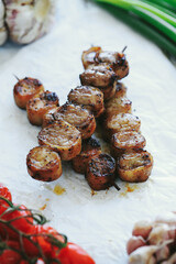 Shashlik or shish kebab prepared on barbecue grill over hot charcoal with grilled vegetables. Grilled pieces of pork meat on metal skewers.
