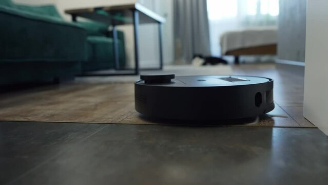 Modern programmable remote control vacuum cleaner on a wooden floor in a home in a low angle view