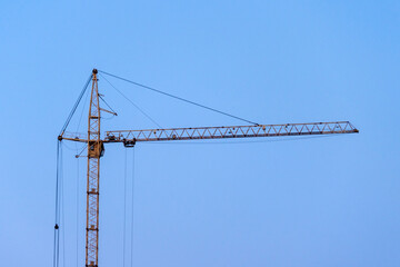A construction crane on a blue sky background. Copy Space