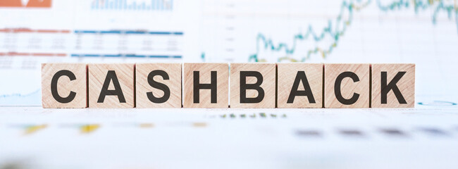 Wooden cubes with letters CASHBACK on white background with charts and diagrams