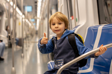 Children, traveling on the subway early in the morning, empty train, Barcelona