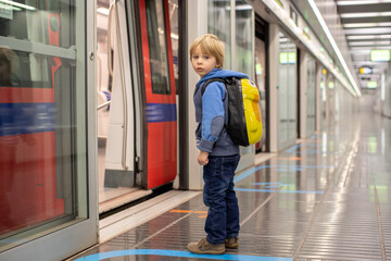 Obraz premium Children, traveling on the subway early in the morning, empty train, Barcelona