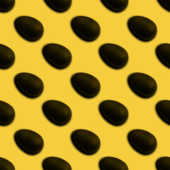 Seamless pattern of halves of black chocolate Easter eggs on a yellow background. Easter sweet chocolate background. Can be used for wallpaper, textile, background