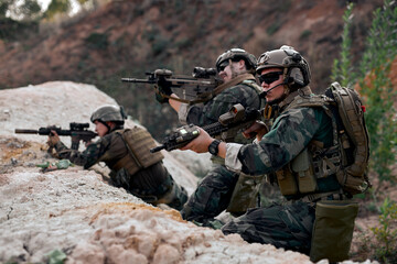 group of army soldiers, shooters wearing combat uniform, body armor and helmet, aiming service...