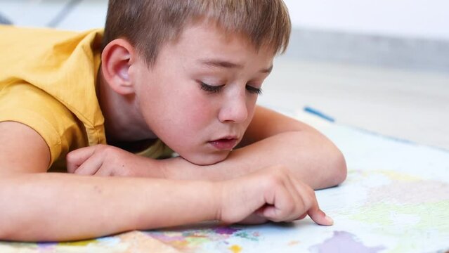 Boy runs his finger on the map