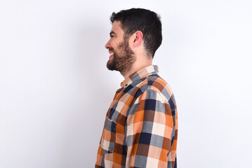 Fototapeta premium Profile portrait of nice young caucasian man wearing plaid shirt over white background look empty space toothy smile