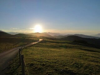 Sunset from the top of the green meadows of a mountain.
