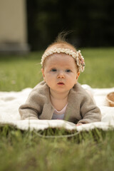 baby girl lies on a plaid, summer picnic for children