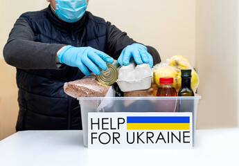 Volunteer prepares to send humanitarian aid to Ukraine. Food box for Ukrainian refugees before...