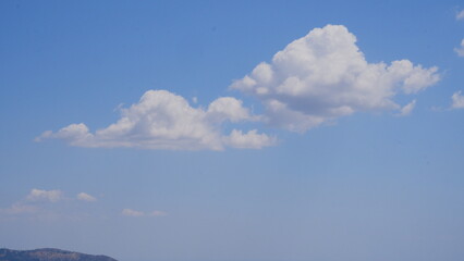 Naklejka na ściany i meble White heap clouds in the blue sky