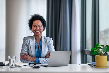 Happy smiling cheerful relaxed confident young adult businesswoman sitting with crossed arms in...