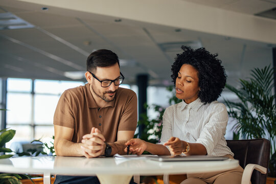 The male boss has a meeting with his female African female, at t