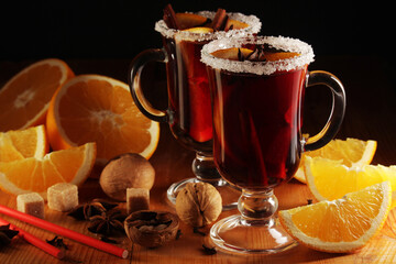 Two cups with ready mulled wine with anise, cinnamon and nuts around
