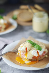 Egg benedict sandwiches - muffin with poached egg, ham and hollandaise sauce