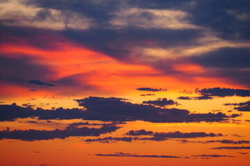 Atardecer en el mar, dorado y con nubes.