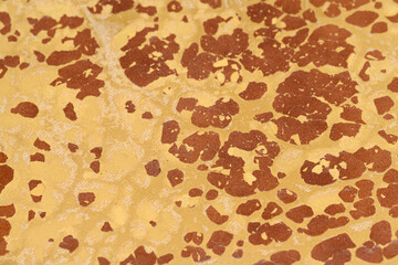 The texture of old cracked artificial leather. The surface of dried leatherette with many cracks and pieces of brown material. The texture of artificial leather.