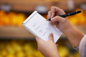 Ticking off her items as she goes along. Closeup shot of a woman checking her shopping list in a...