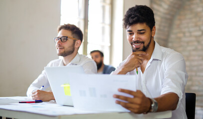 Group of happy multiethnic business people cooperating, working on meeting in corporate office
