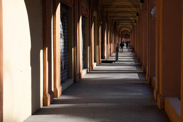 Beautiful streets of Bologna in the morning, arcaded streets with columns