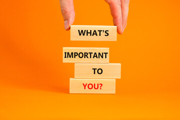 What is important to you symbol. Concept words What is important to you on blocks. Businessman hand. Beautiful orange table orange background. What is important to you business concept. Copy space.