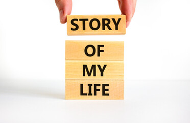 Story of my life and storytelling symbol. Concept words Story of my life on wooden blocks. Businessman hand. Beautiful white table white background. Story of my life business concept. Copy space.