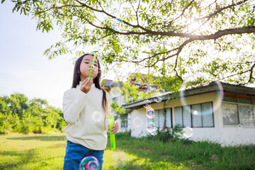 A little girl blowing soap bubbles with have fun and enjoyed on sunny days on weekend.