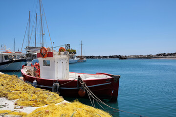 View of a fishboat and fishnets next to it at a small harbor in Santorini Greece
