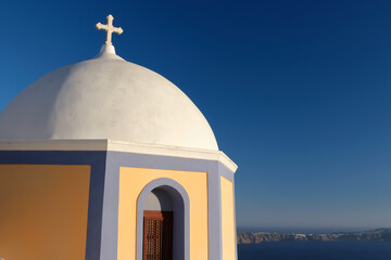 Fototapeta na wymiar View of a beautiful orthodox church, the blue sky and the Aegean Sea in Santorini Greece