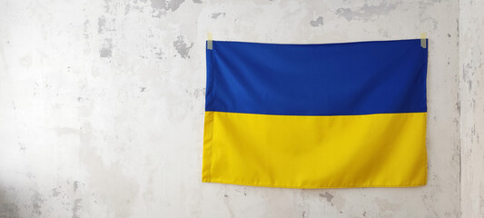 Ukrainian flag hangs on the concrete wall of the military base