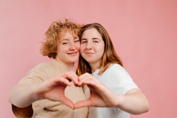 Selective focus on of two lesbian girls announcing their relationship on Valentines Day, looking at the camera and smiling. Free expression of love. Being with a loved one on a Valentines Day
