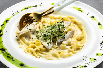 Pasta alfredo with chicken, Fettuccine alfredo in a creamy sauce with chicken, parmesan on white plate. Italian cuisine. Restaurant menu, dieting, cookbook recipe top view