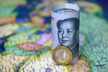 Chinese yuan and russian coin rubles on the map. Concept of economic cooperation between the China and Russia, exchange rate