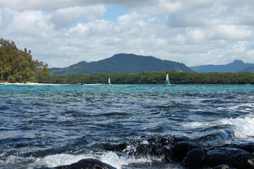 Windsurfers on the horizon of a resort island with mountains in the background, île des deux...