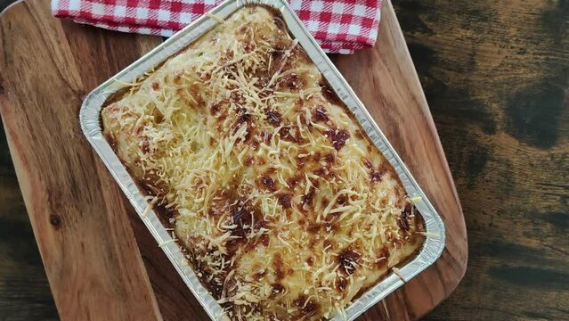 spinach salmon lasagna in a dish on a wooden board