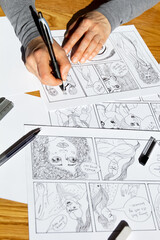 The artist draws frames of comic book characters. An animator designer creates a storyboard.