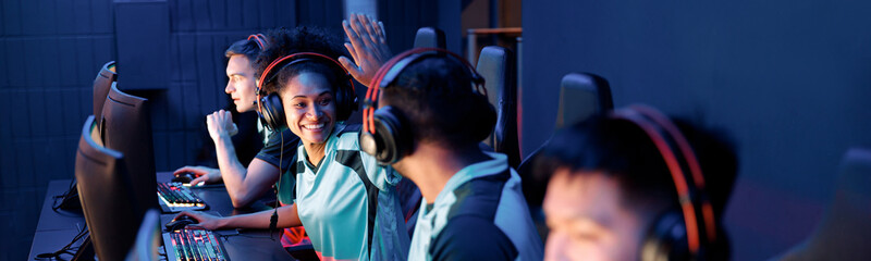 Two happy esports team members celebrating success while giving high five to each other in gaming...