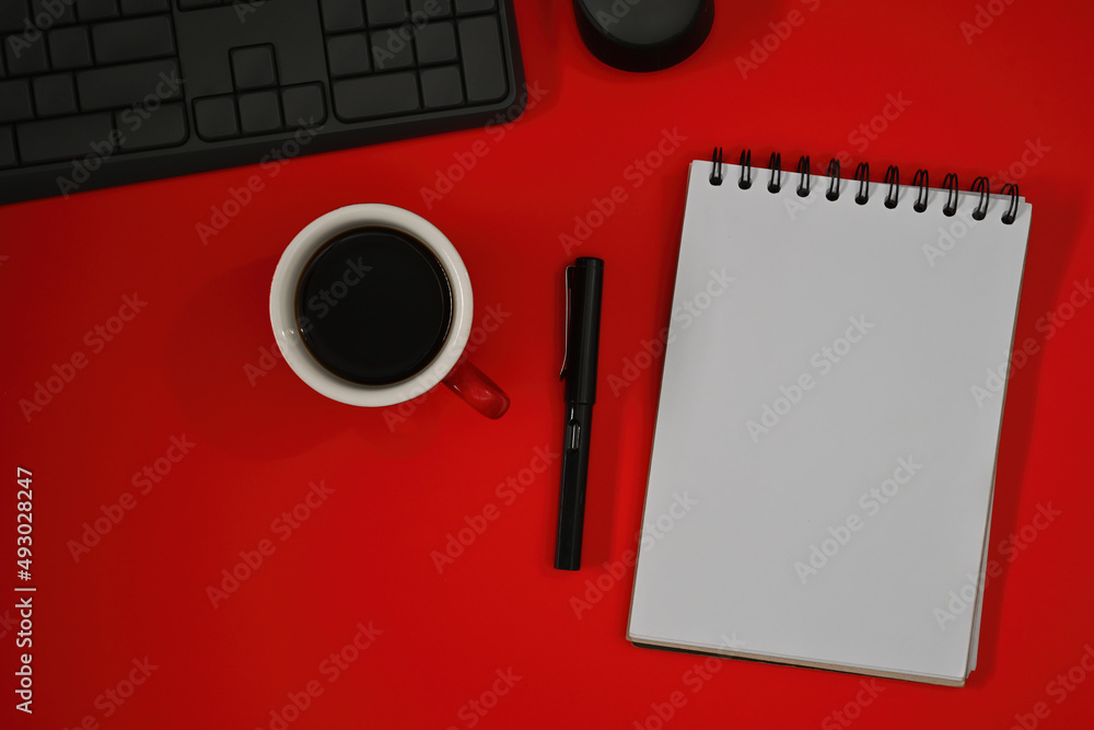 Poster top view flat lays of note book, keyboard and a cup of coffee on a red background with empty space f
