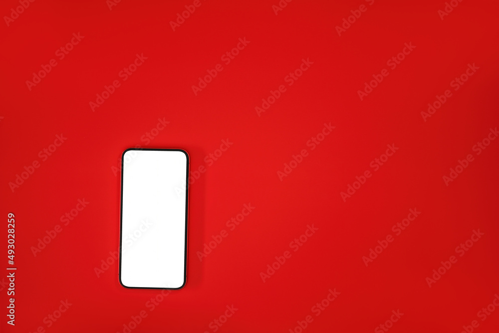Poster top view flat lay of a smartphone with blank white screen on a red background with a lot of empty sp