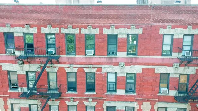 Four story apartment building with fire escape leading to rooftop