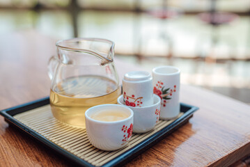 Tea in glass with tea jug set on the wooden table, Chinese and Japanese cultures.