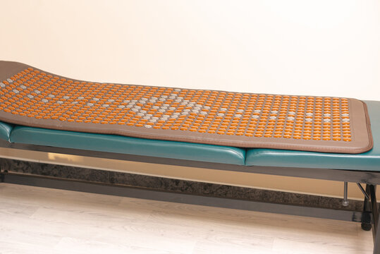 Photo of infrared heating mattress with Tourmanium lying on a massage bed.